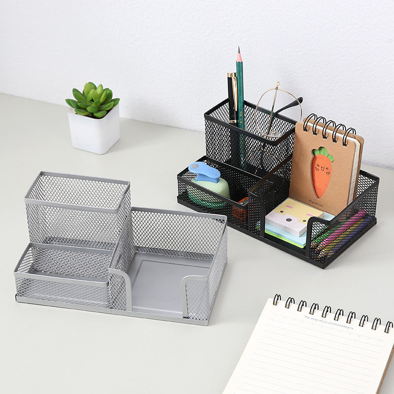 Black and silver metal mesh desk organisers with multiple compartments on a white desk
