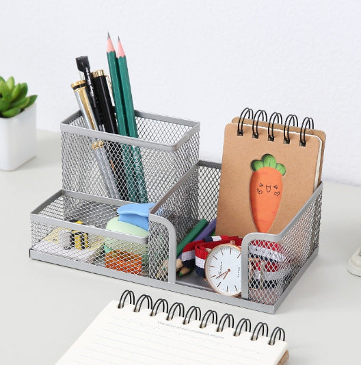 Silver metal mesh pen and stationery organiser filled with pencils and small desk accessories