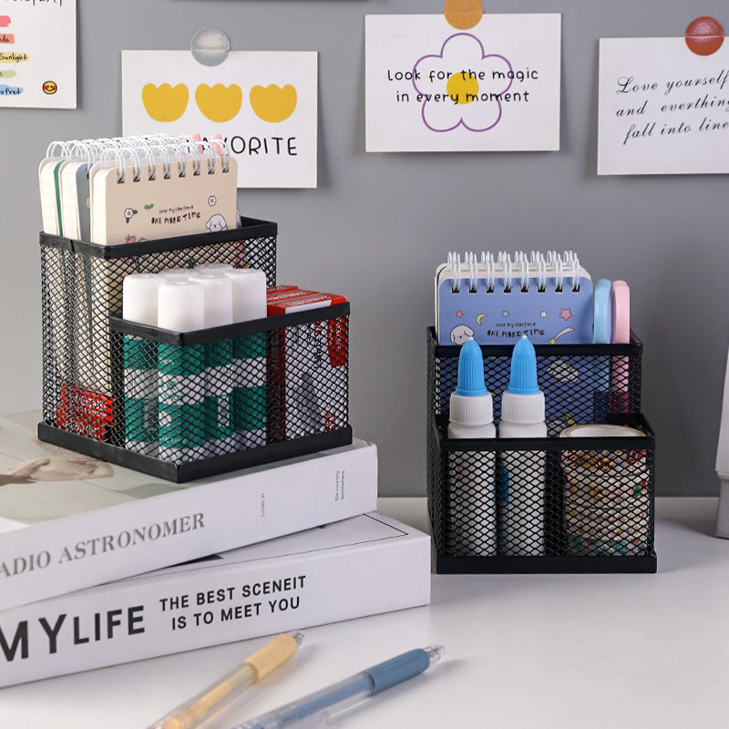 Black metal mesh stationery organisers holding notebooks, markers and pens on an office desk