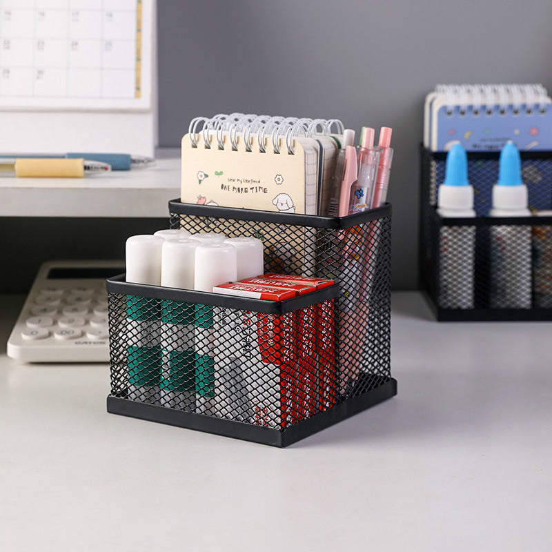 Black metal mesh organiser shown on a desk with notebooks and stationery