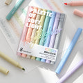 Eight pastel-coloured highlighters in clear retail packaging with pens alongside