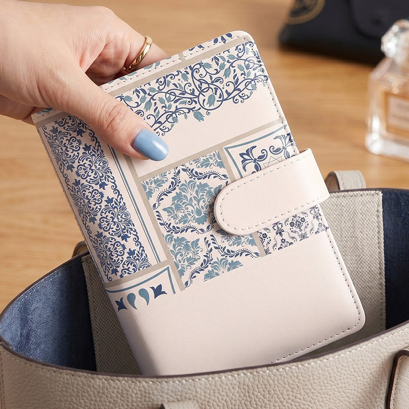 Person holding a patterned A6 cash budget binder with magnetic strap closure